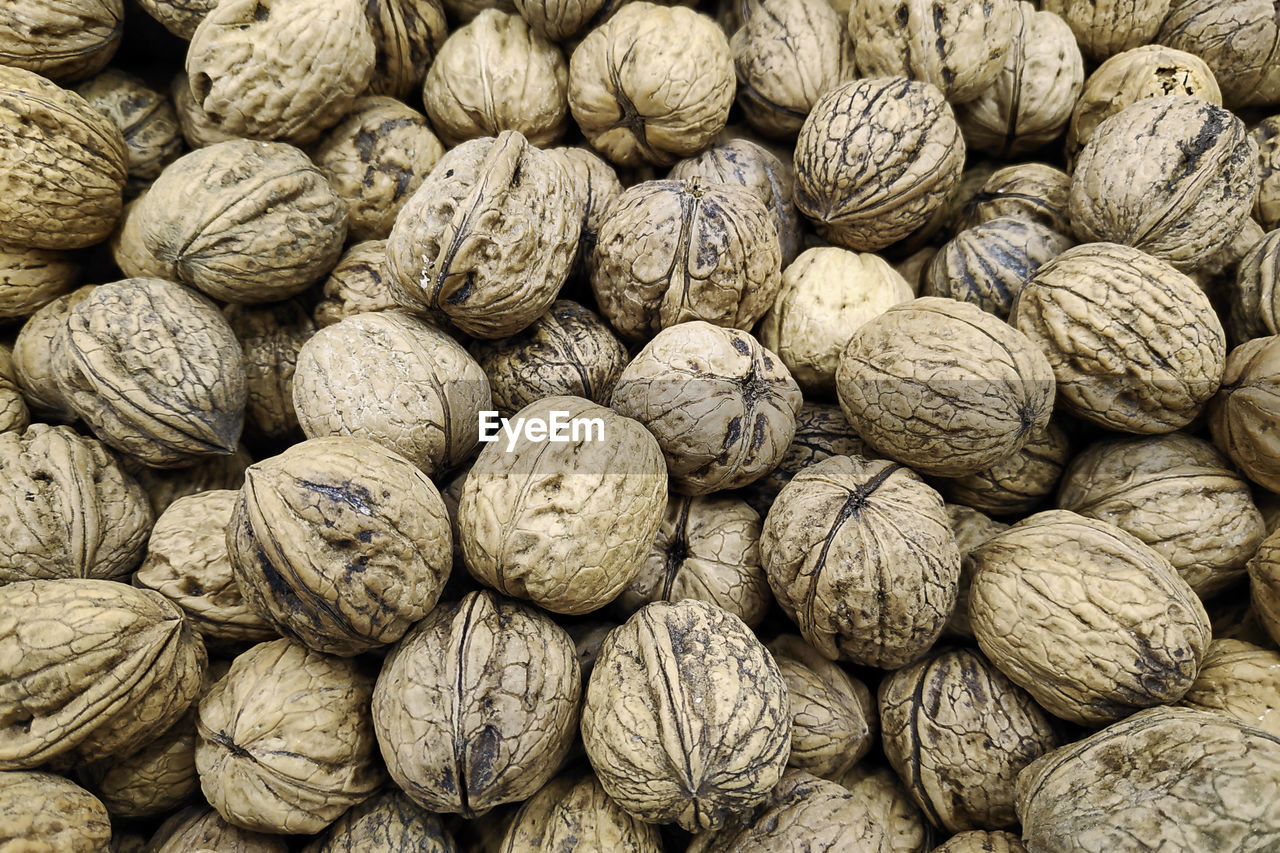 Close-up on a stack of walnuts on a market stall.