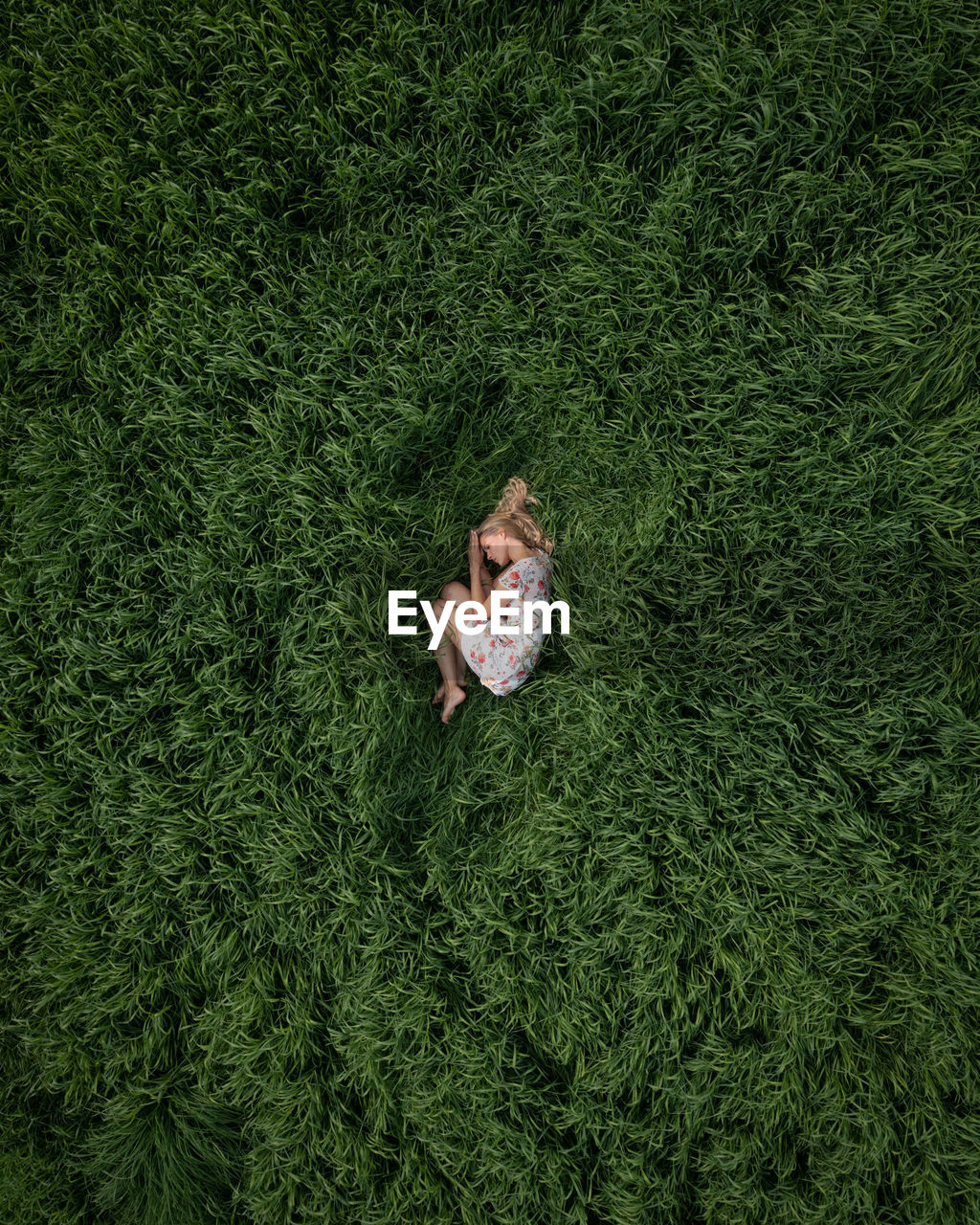 HIGH ANGLE VIEW OF WOMAN LYING DOWN ON GRASS