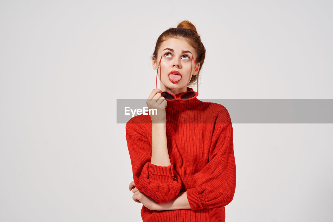 PORTRAIT OF BEAUTIFUL YOUNG WOMAN AGAINST WHITE BACKGROUND