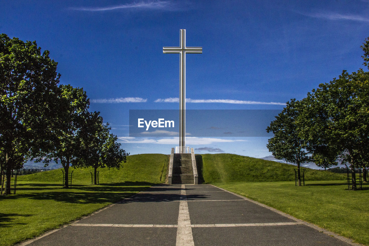 Large cross on landscape against blue sky