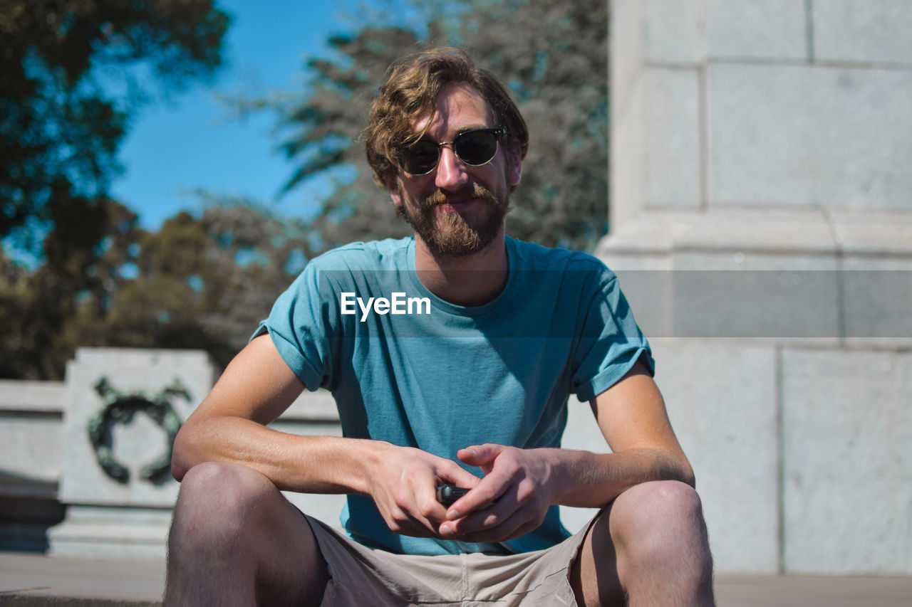 Man in sunglasses sitting outdoors