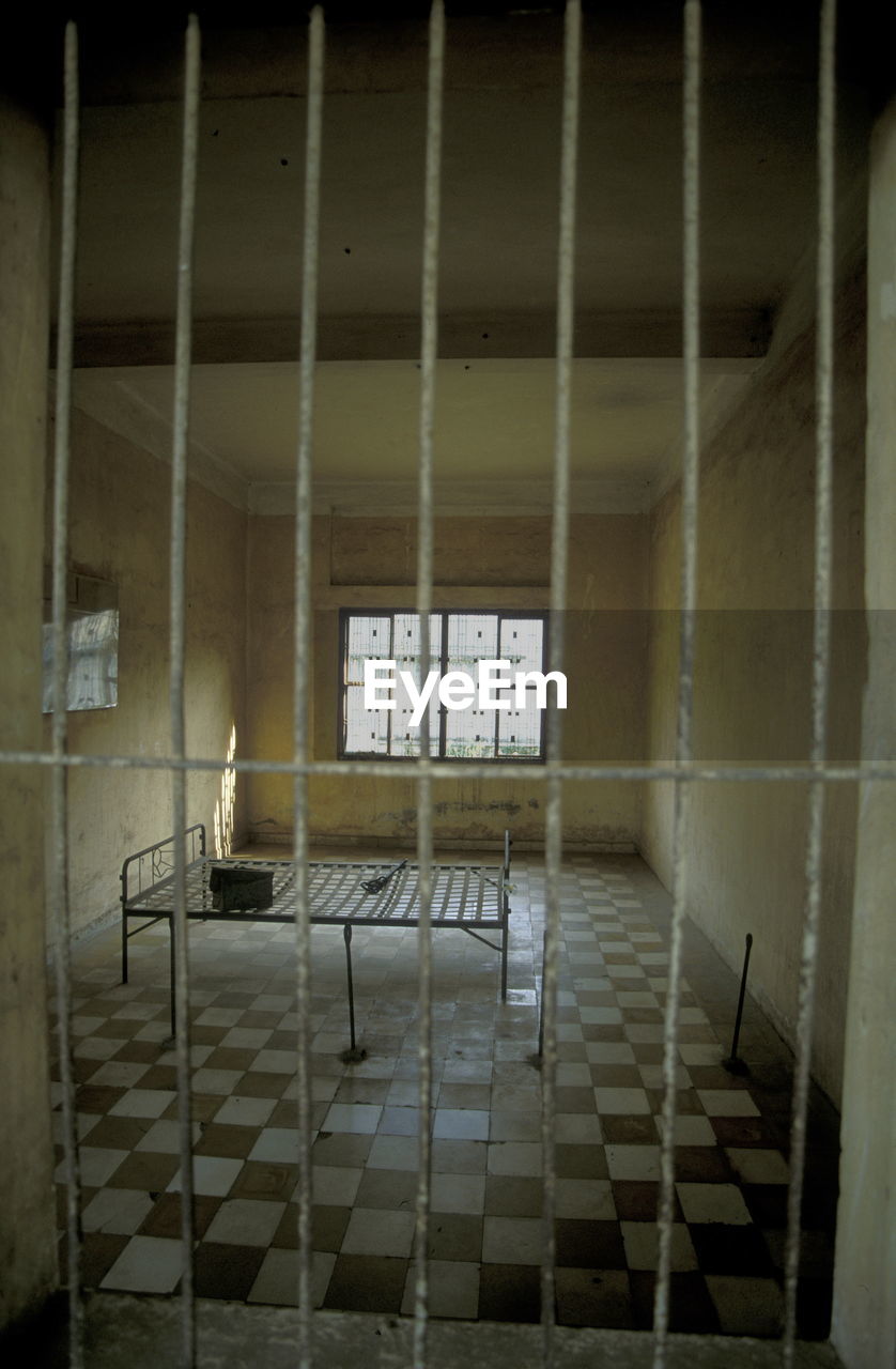 Bed on checked patterned floor at prison cell