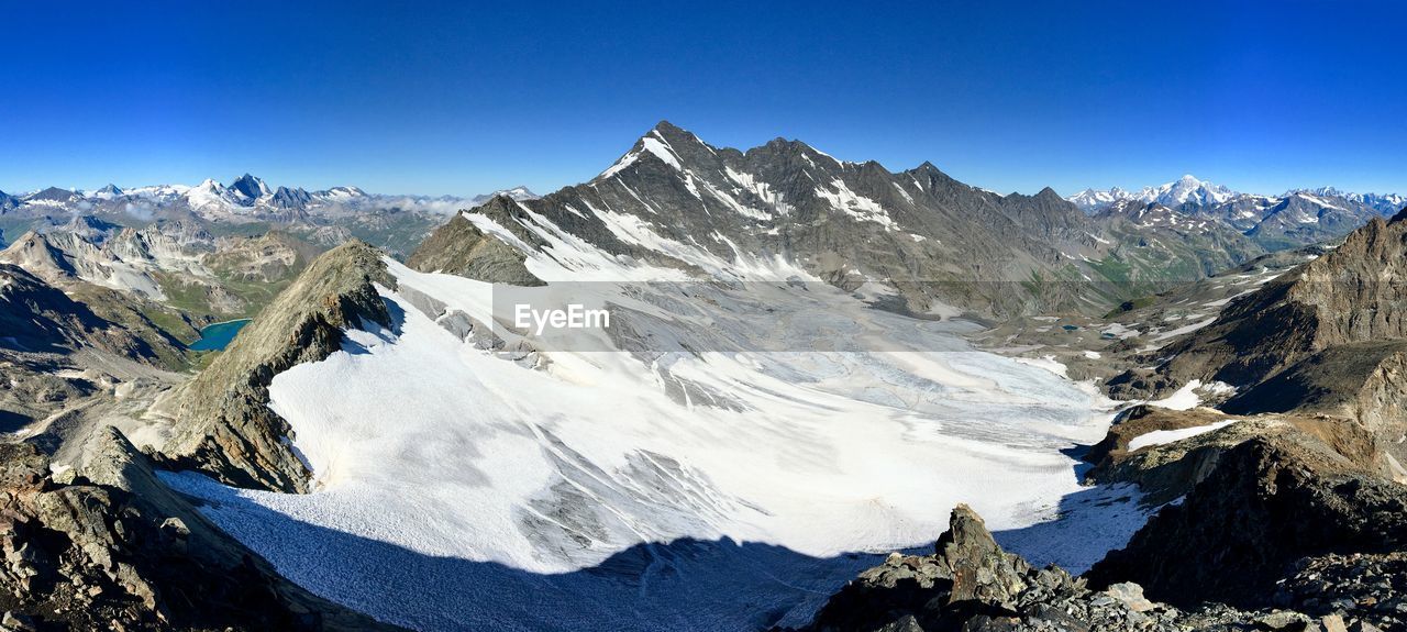 Scenic view of snowcapped mountains against clear blue sky