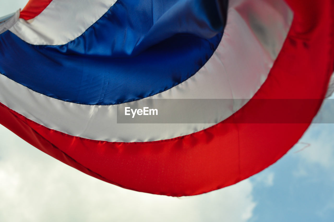 CLOSE-UP OF FLAG AGAINST BLUE SKY