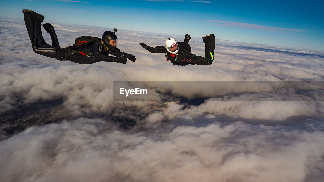 sky, nature, motion, sports, cloud, adult, men, leisure activity, communication, adventure, mid-air, transportation, extreme sports, environment, joy, mountain, full length, outdoors, two people, flying, day, landscape, exhilaration, mode of transportation, aerial view, activity, parachuting, speed, travel, risk, cold temperature