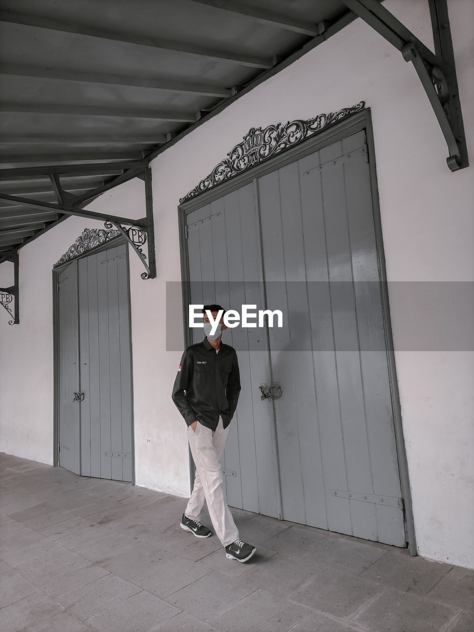 PORTRAIT OF MAN STANDING AGAINST CEILING