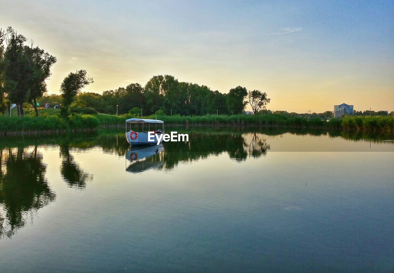 Reflection of boat and plants in calm water