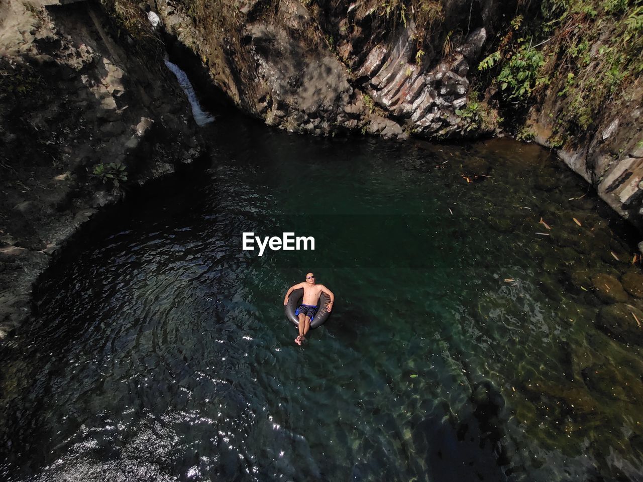 High angle view of man swining in the waterfall