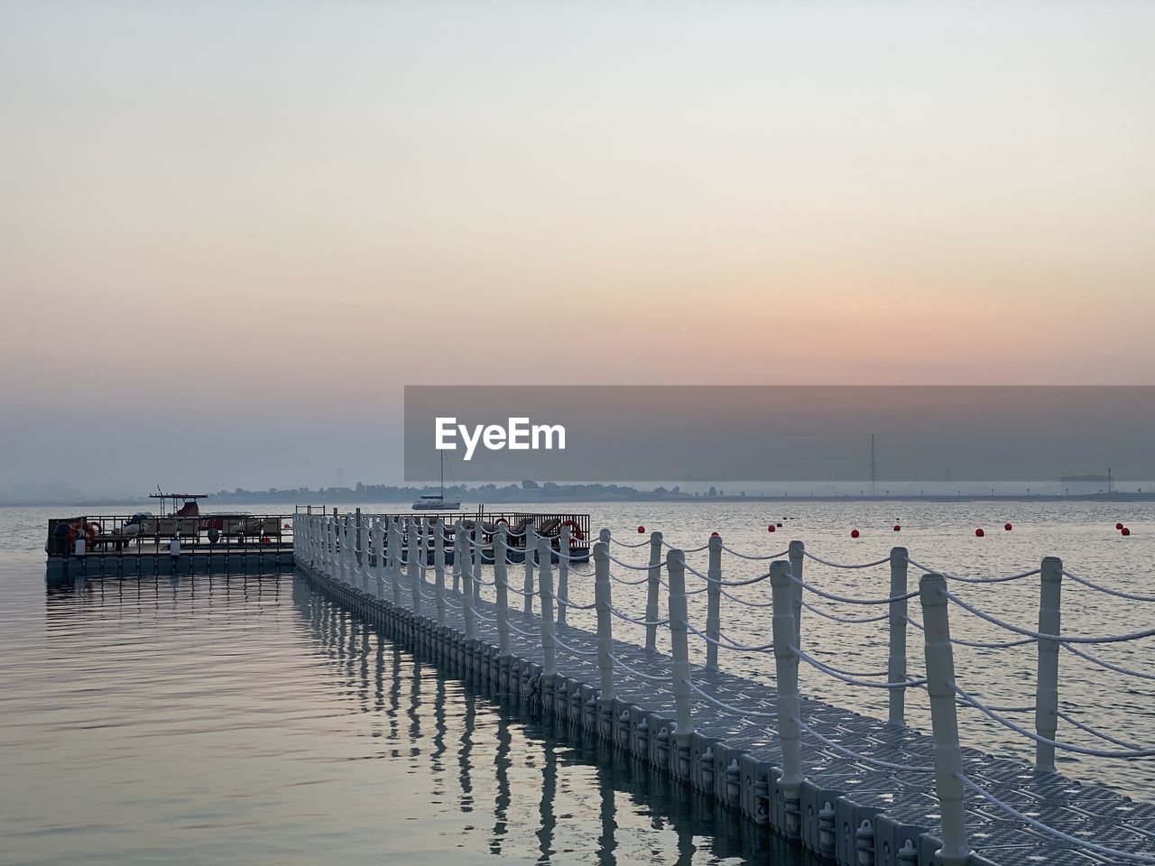 Pier over sea against sky during sunset