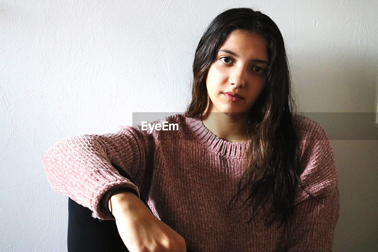 Portrait of beautiful young woman sitting at home