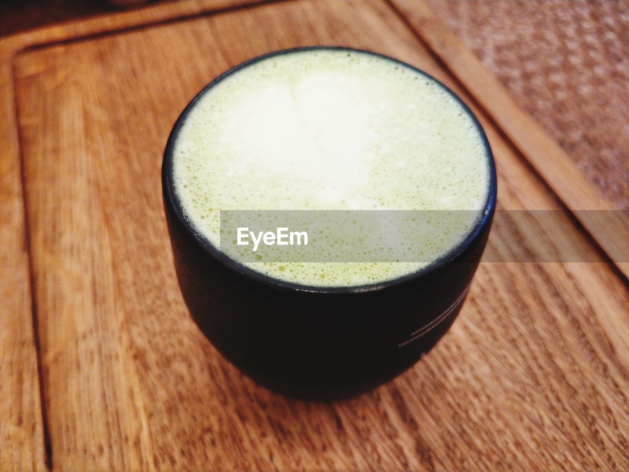 High angle view of cup with matcha tea on table