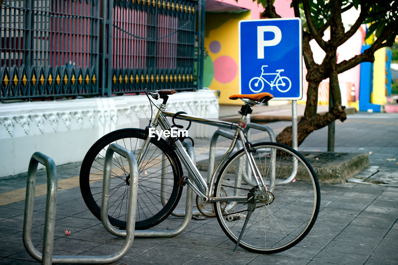 Bicycle sign on railing in city