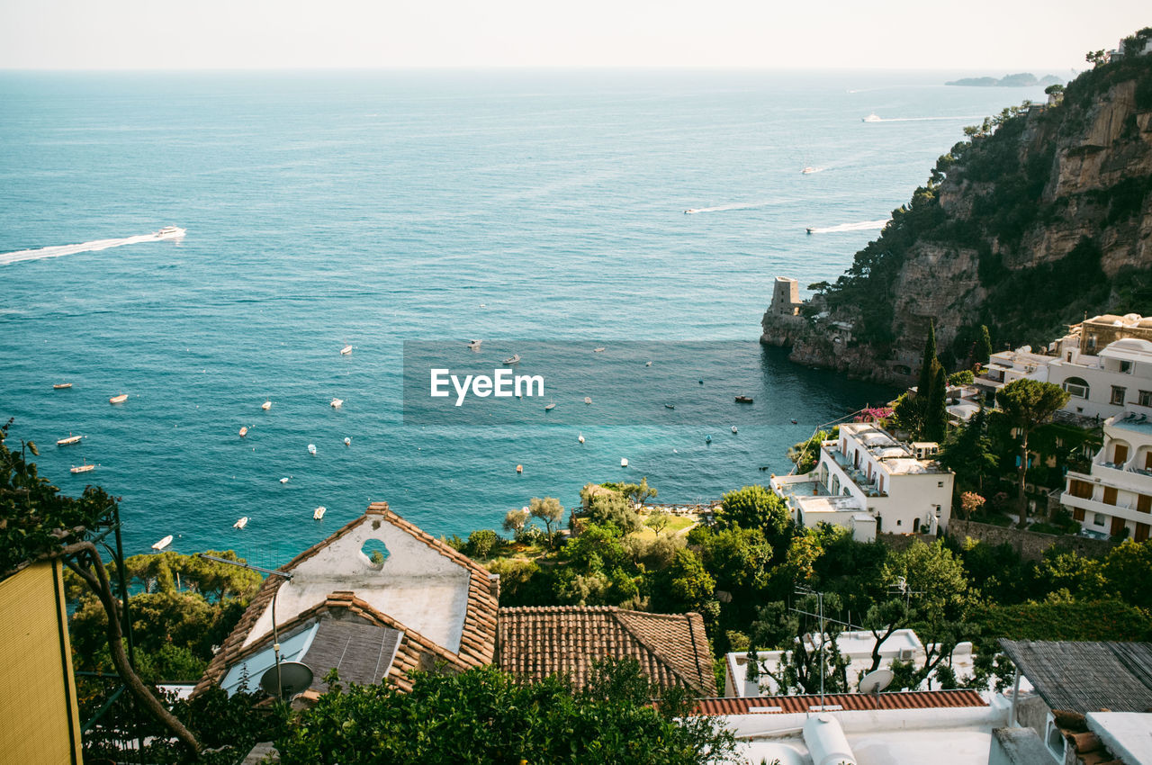 High angle view of buildings and rocky mountains against sea at positano