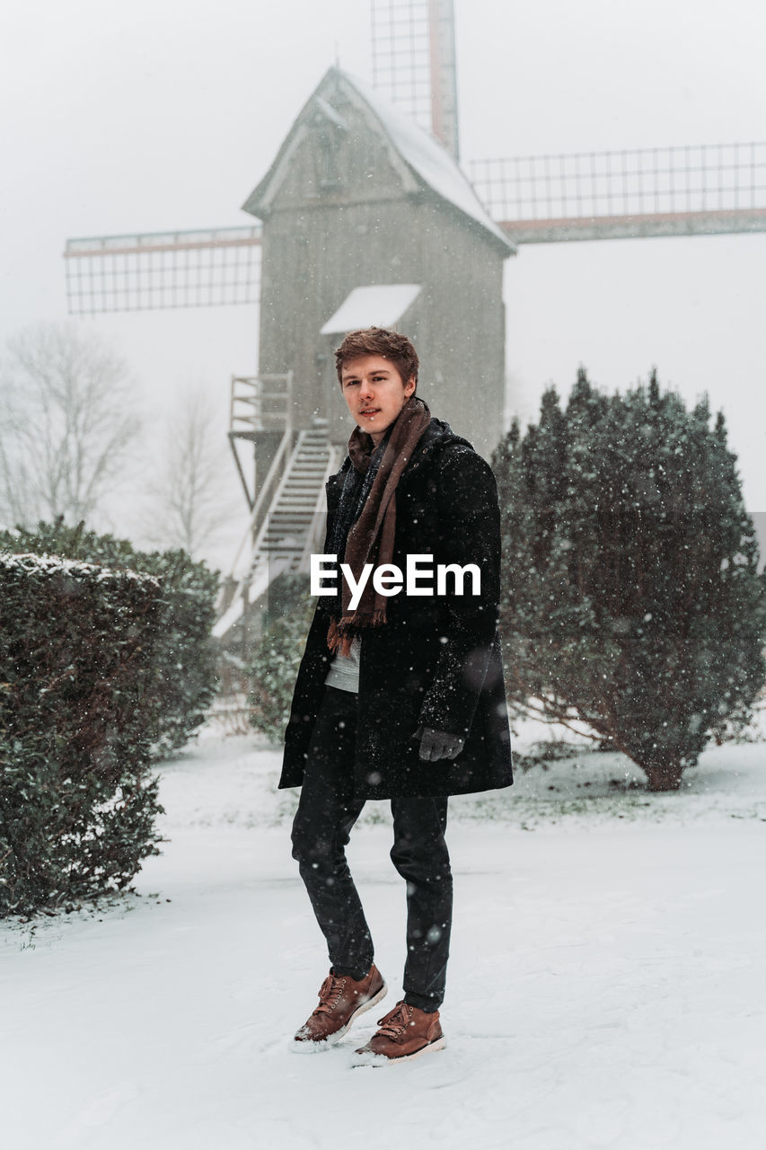 Portrait of young man standing on snow