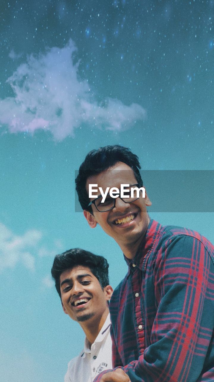 PORTRAIT OF SMILING YOUNG MAN AGAINST STAR AND BLUE SKY