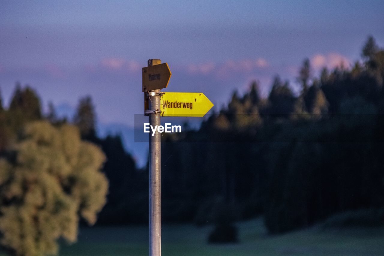 Close-up of road sign against sky