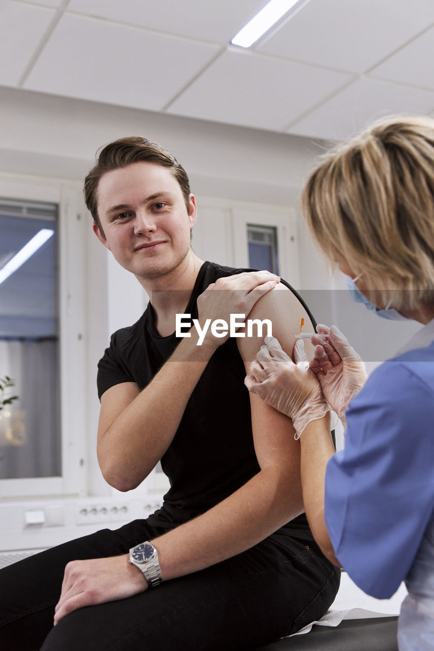 Portrait of young man getting vaccinated against covid-19