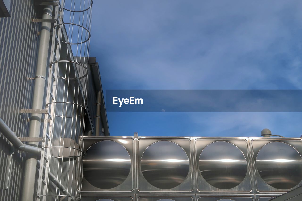 LOW ANGLE VIEW OF FACTORY AGAINST CLOUDY SKY