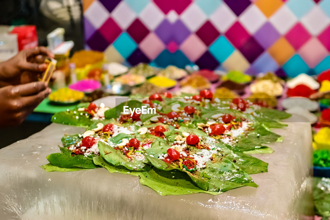 CLOSE-UP OF HAND HOLDING FOOD ON TABLE