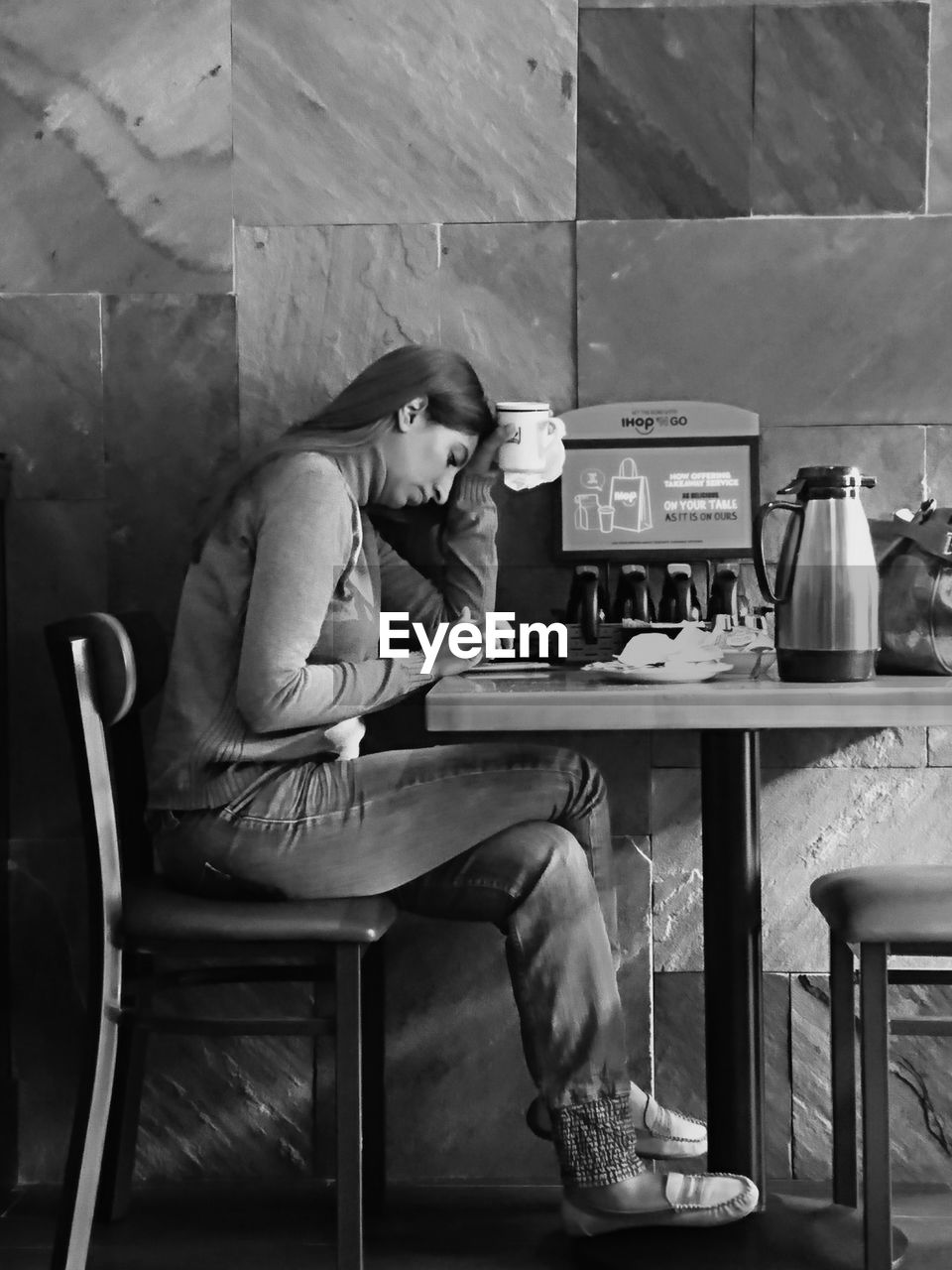 WOMAN SITTING ON TABLE WITH UMBRELLA