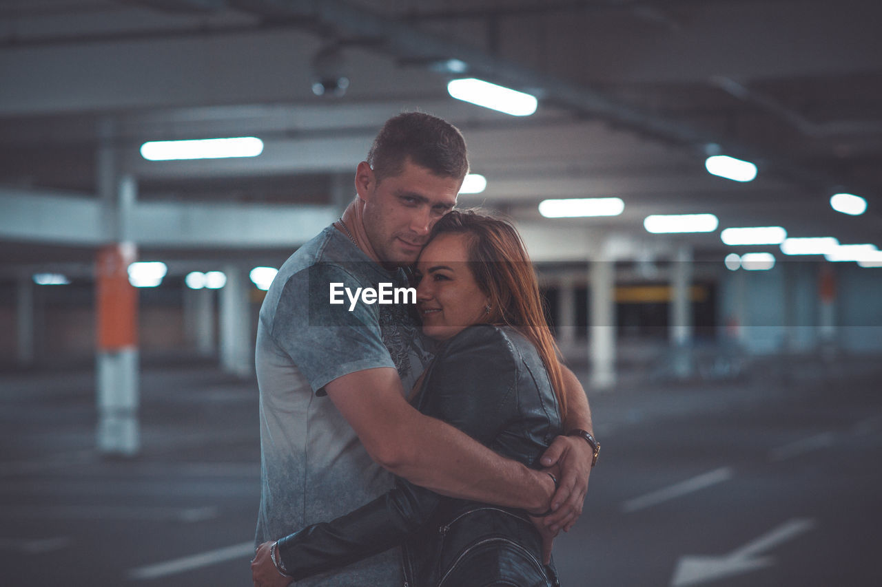 Couple embracing in parking lot