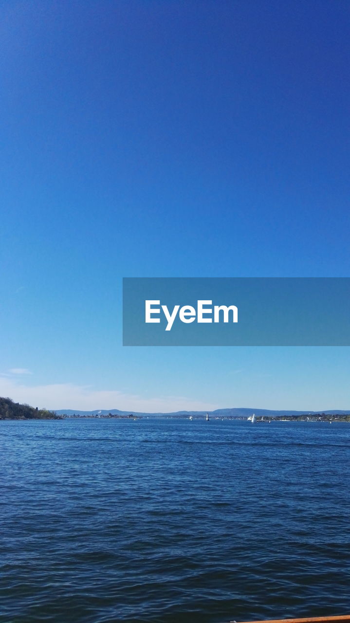 Scenic view of sea against clear blue sky