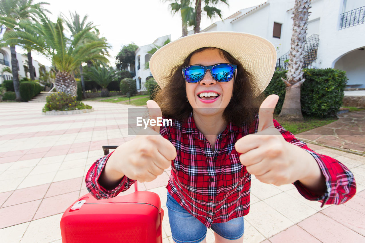 PORTRAIT OF YOUNG WOMAN IN SUNGLASSES