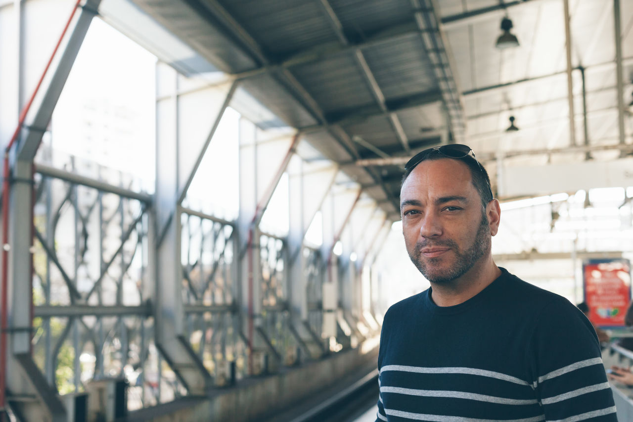 Portrait of mid adult man standing on railroad station platform