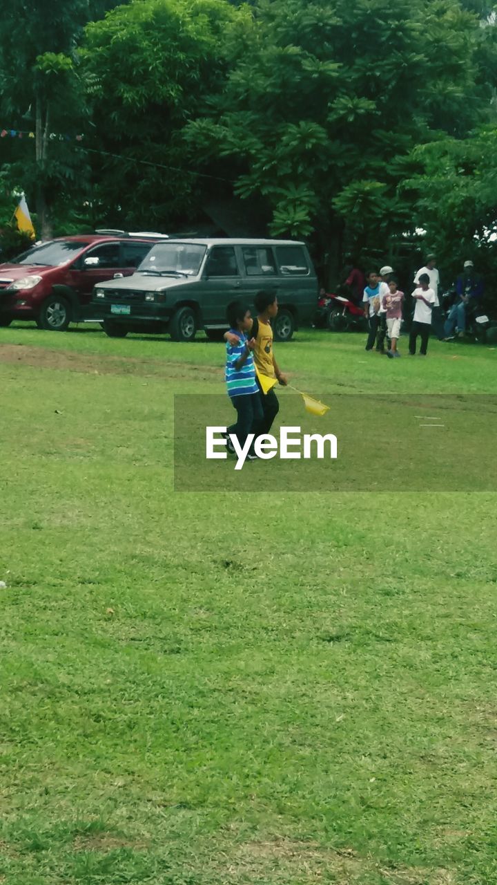 FULL LENGTH OF BOY STANDING ON GRASS