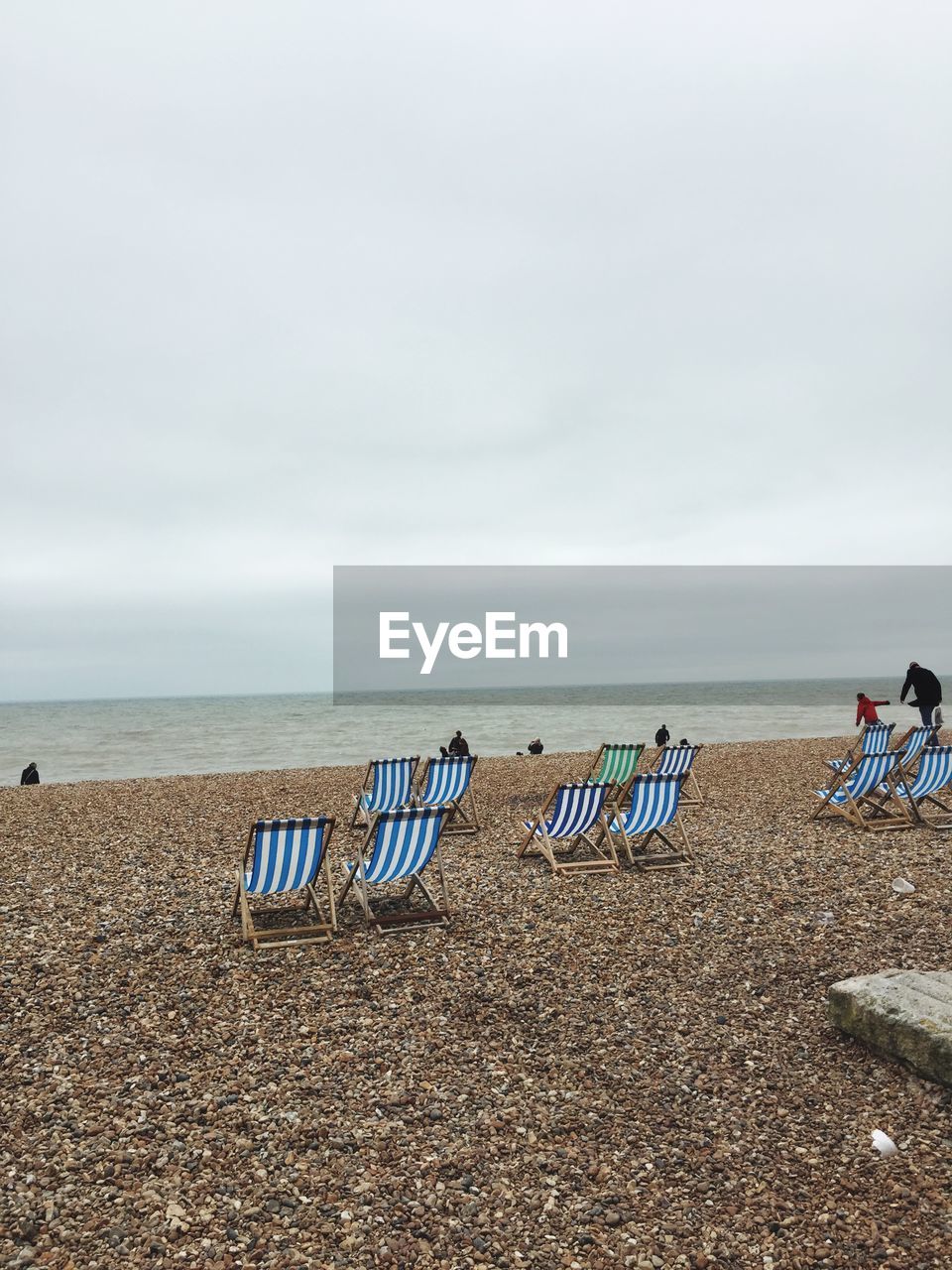 Chairs on beach against sky