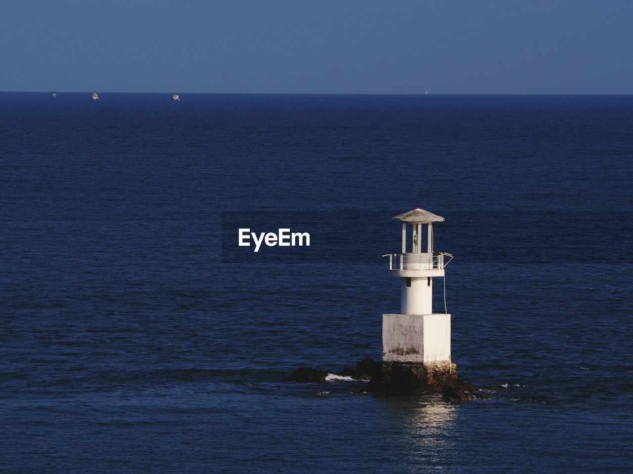 LIGHTHOUSE IN SEA AGAINST CLEAR SKY