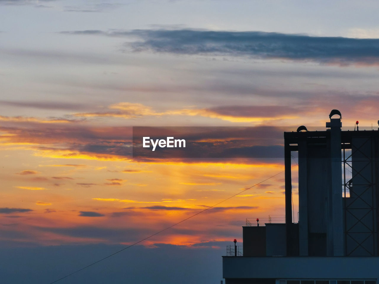 LOW ANGLE VIEW OF SILHOUETTE FACTORY AGAINST SKY DURING SUNSET