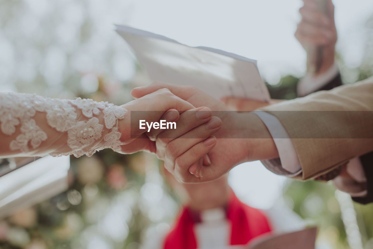 CLOSE-UP OF HANDS HOLDING BLURRED MOTION OF PEOPLE