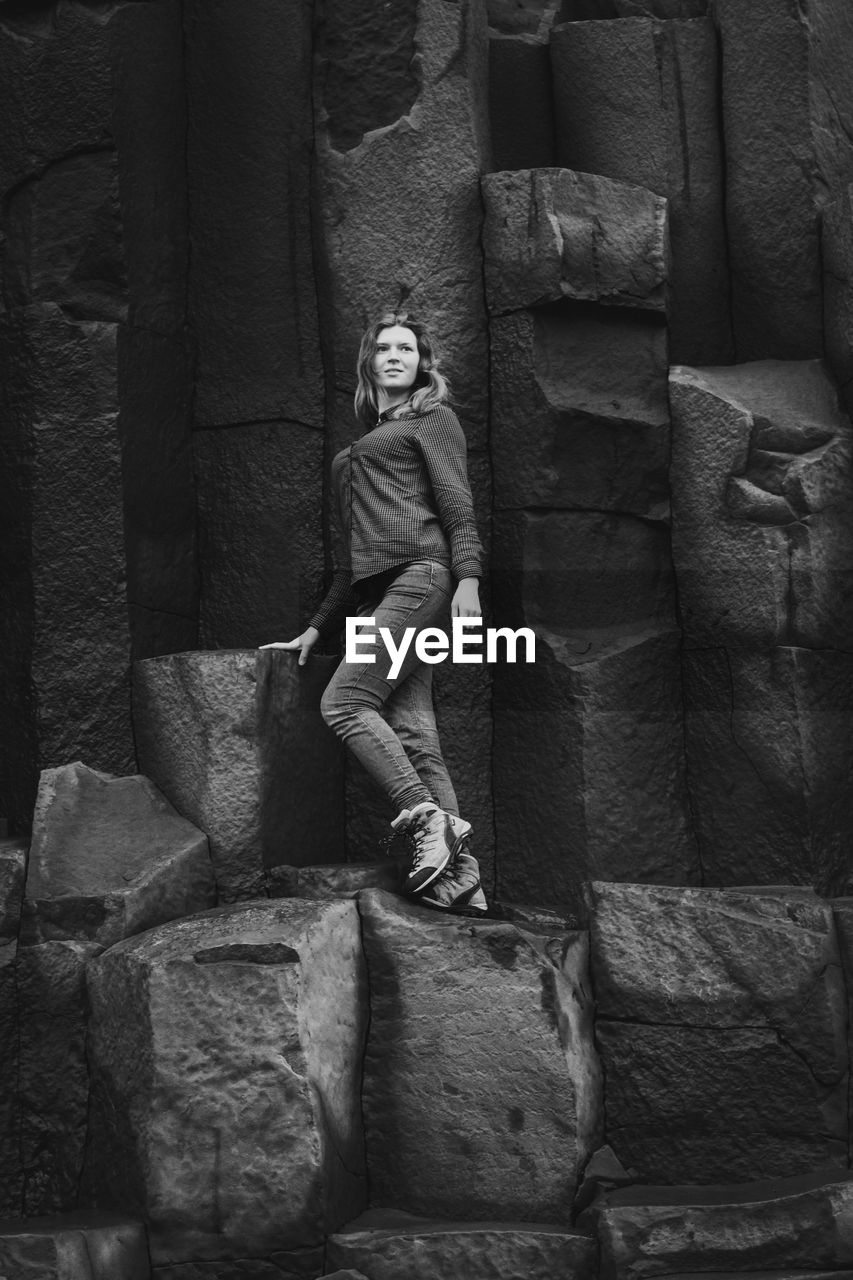 Tourist standing on basalt columns monochrome scenic photography