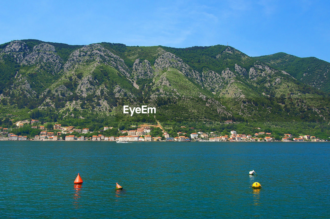 Buoys in water against mountains