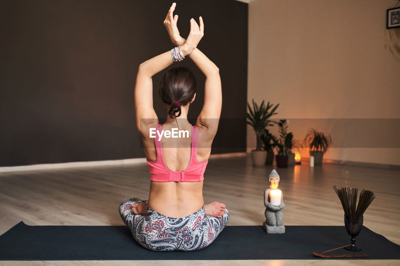 Young woman meditating alone with a yoga studio