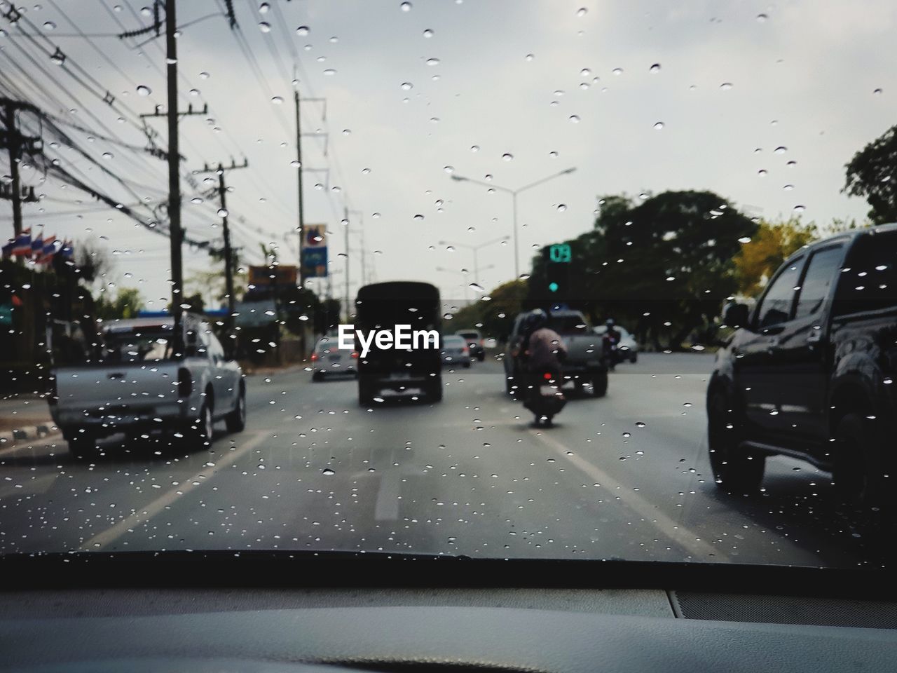 CARS ON ROAD SEEN THROUGH WET GLASS WINDOW