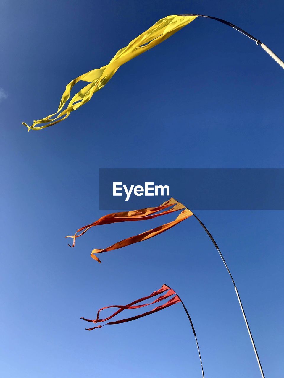 Low angle view of flag against clear blue sky