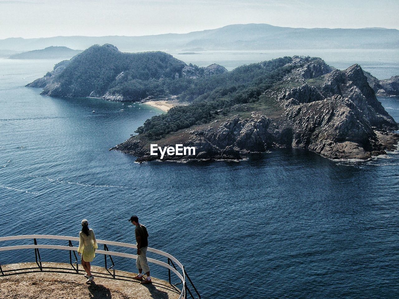 High angle view of man and woman at observation point by sea