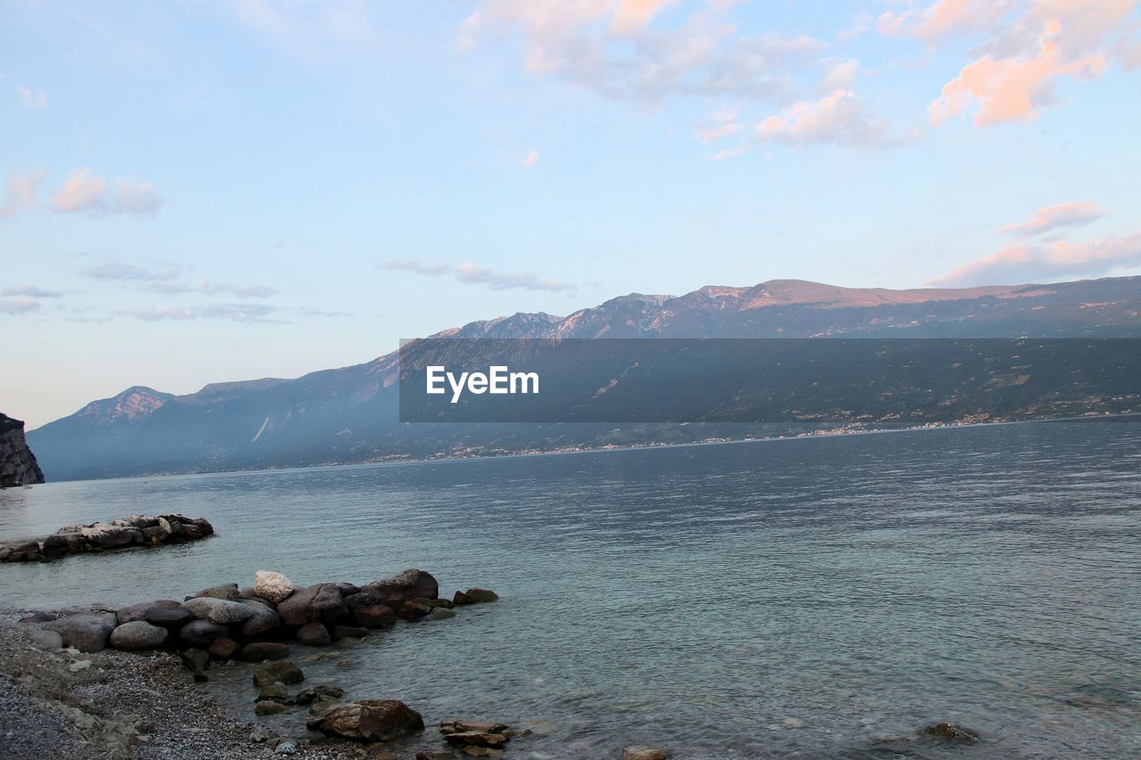 Scenic view of sea and mountains against sky