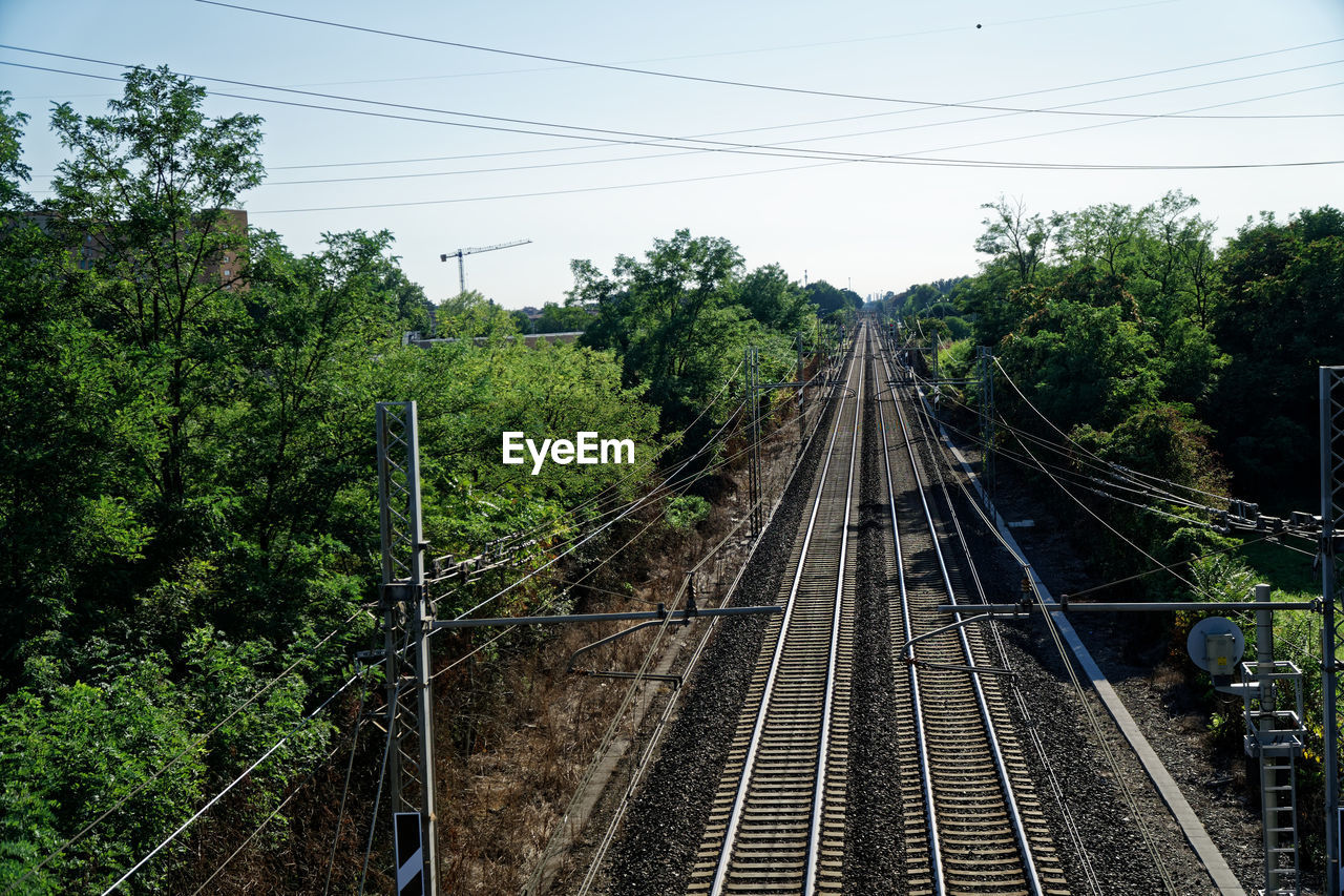 Railroad tracks by trees against sky