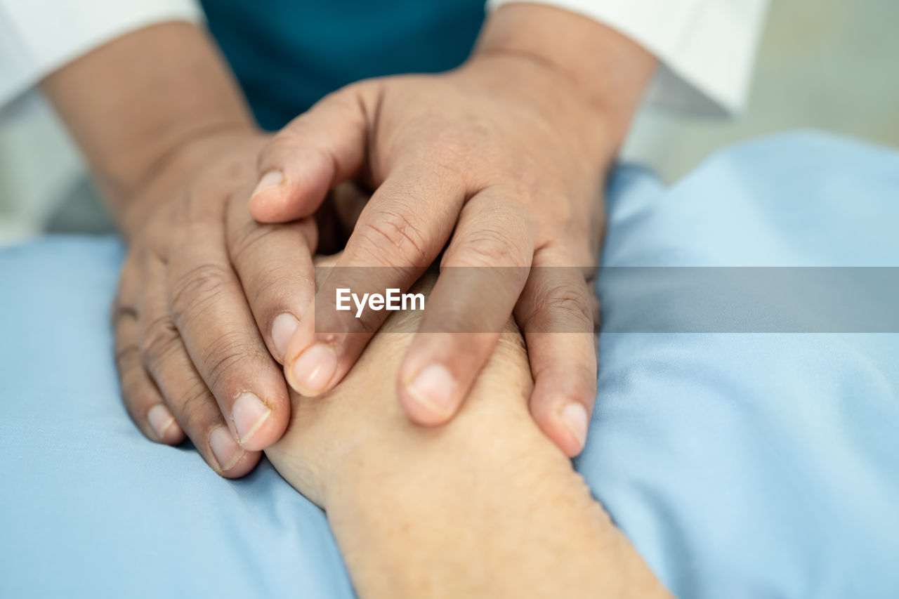 CLOSE-UP OF COUPLE HANDS WITH BABY