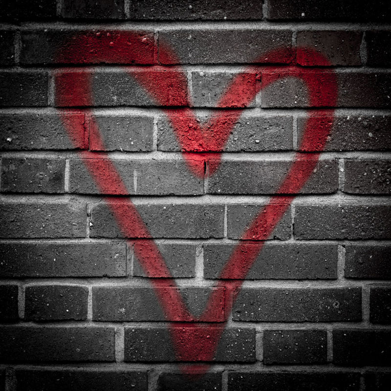 Red heart drawn on brick wall