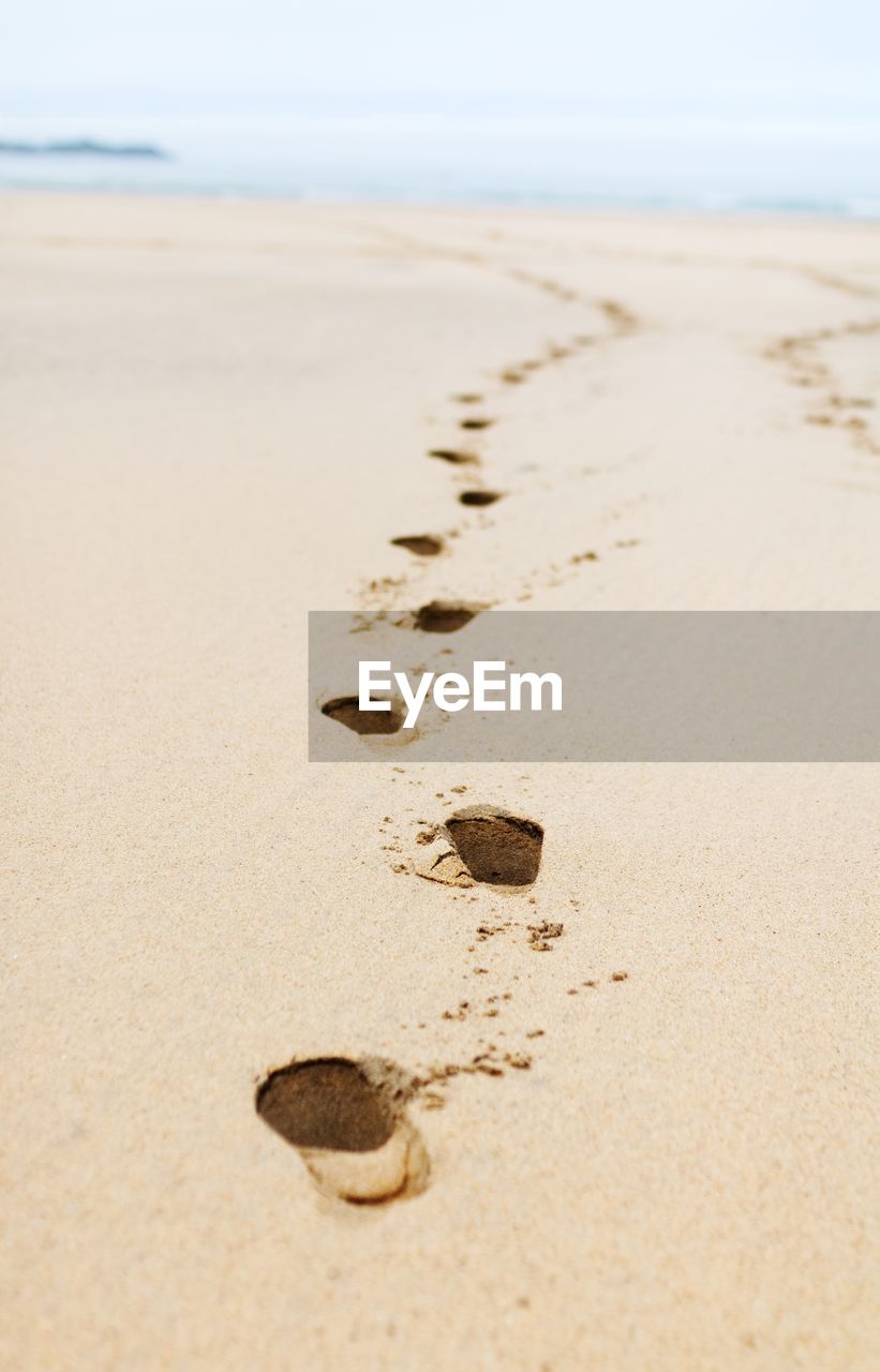 Close-up of footprints on sand at beach