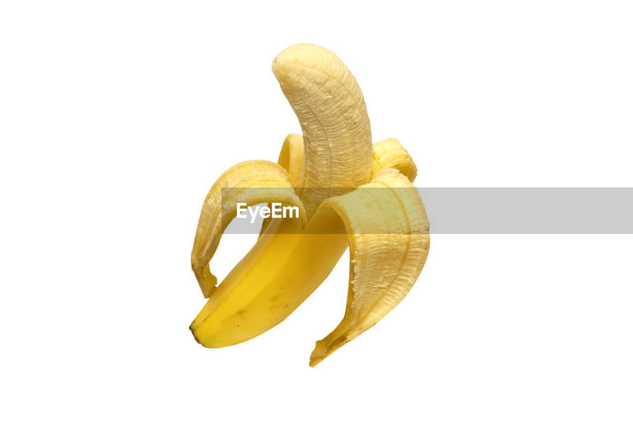 CLOSE-UP OF YELLOW FRUIT ON WHITE BACKGROUND