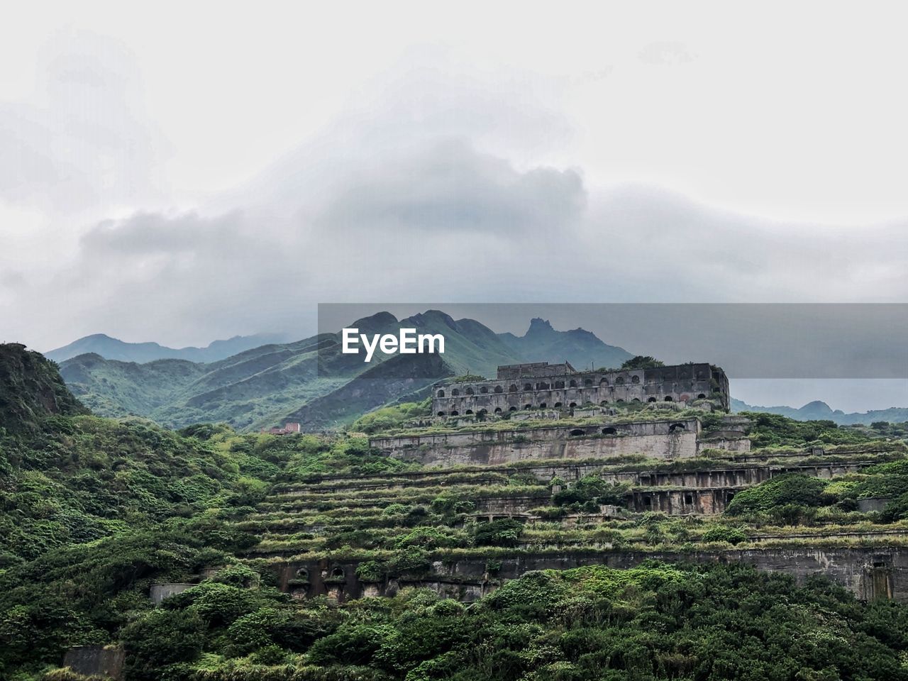 Scenic view of lost city on mountains against cloudy sky