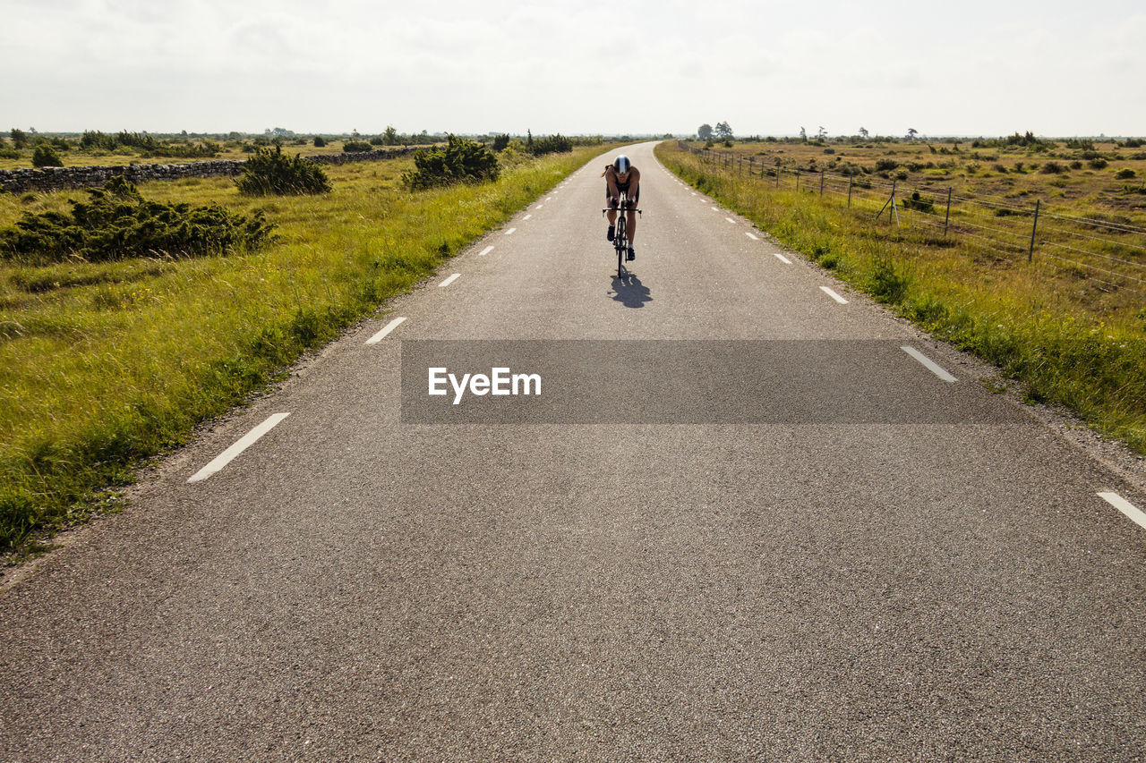 Person cycling on country road