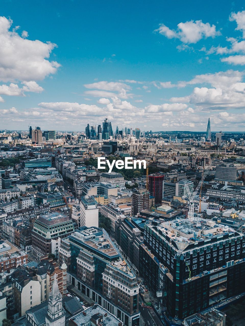 High angle view of city buildings against cloudy sky