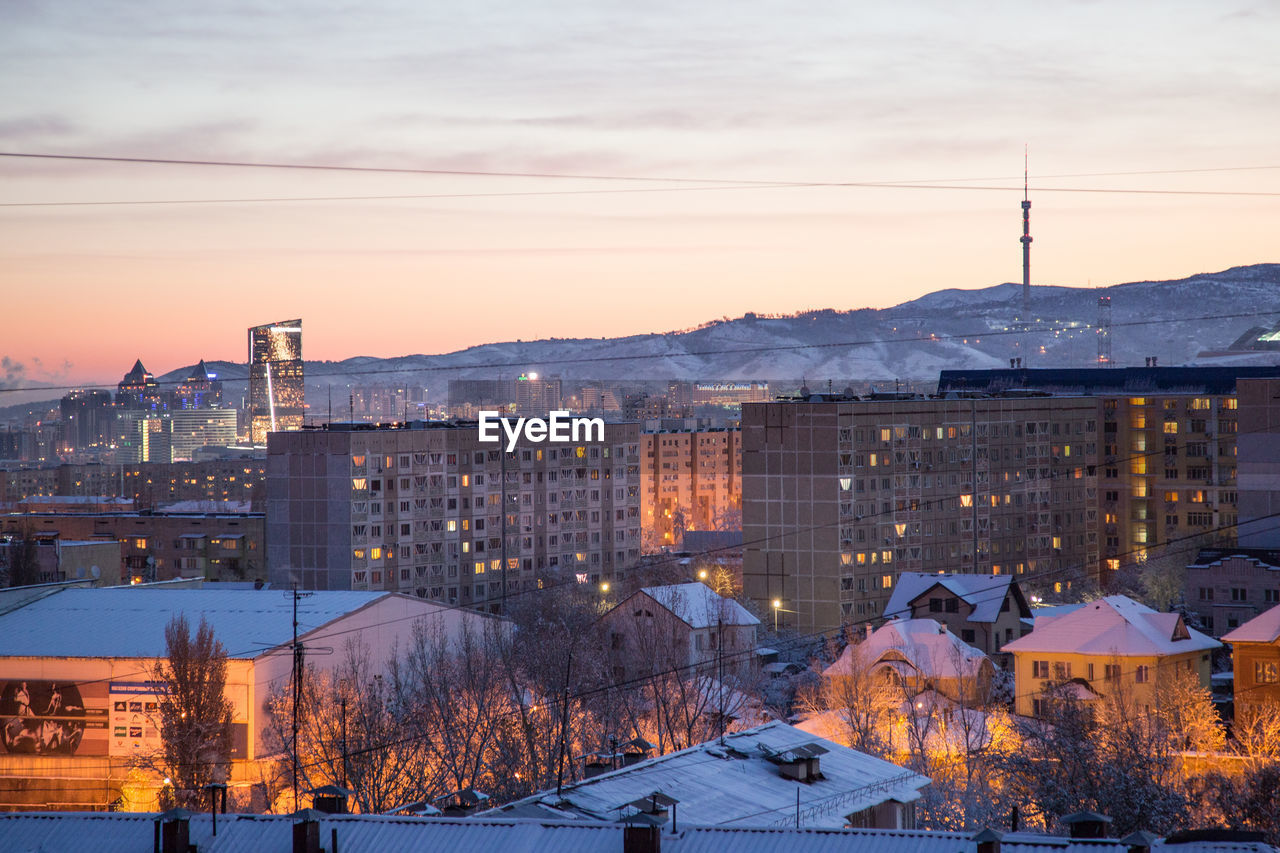 HIGH ANGLE VIEW OF CITY DURING WINTER AT SUNSET