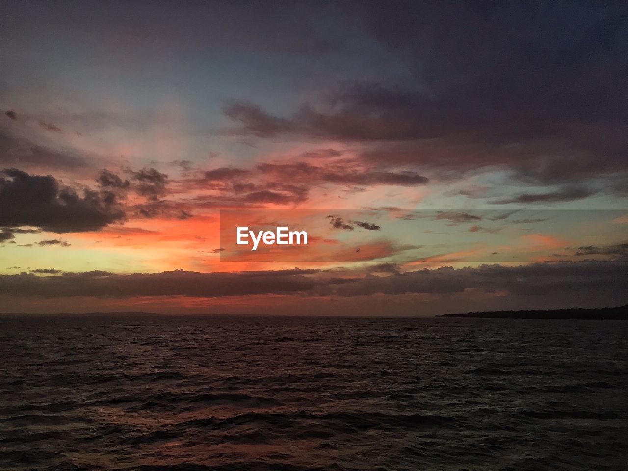 Scenic view of sea against sunset sky